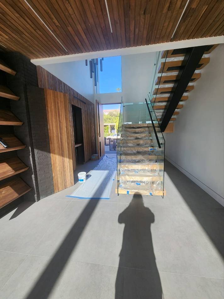 Floating staircase with glass railing and custom millwork delivered on a builder project